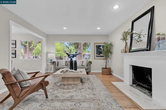 a living room with furniture a large window and a fireplace