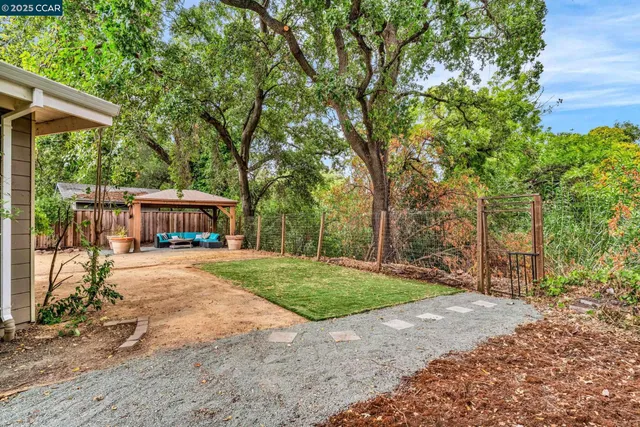 a view of a house with backyard and sitting area