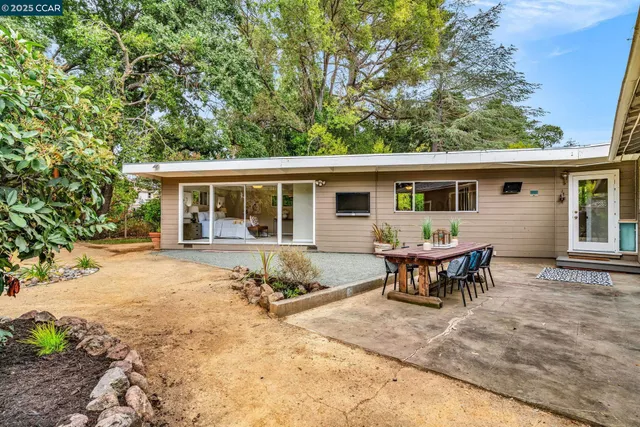 a view of a house with backyard and sitting area