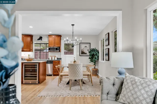 a living room with furniture a chandelier and kitchen view