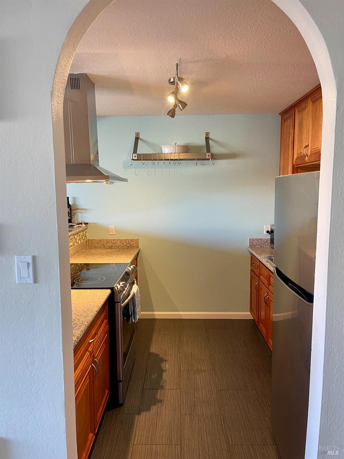 1 Embarcadero West, Unit 355 Oakland, CA 94607 - Photo 8 of 20 a view of a kitchen with fridge and wooden floor