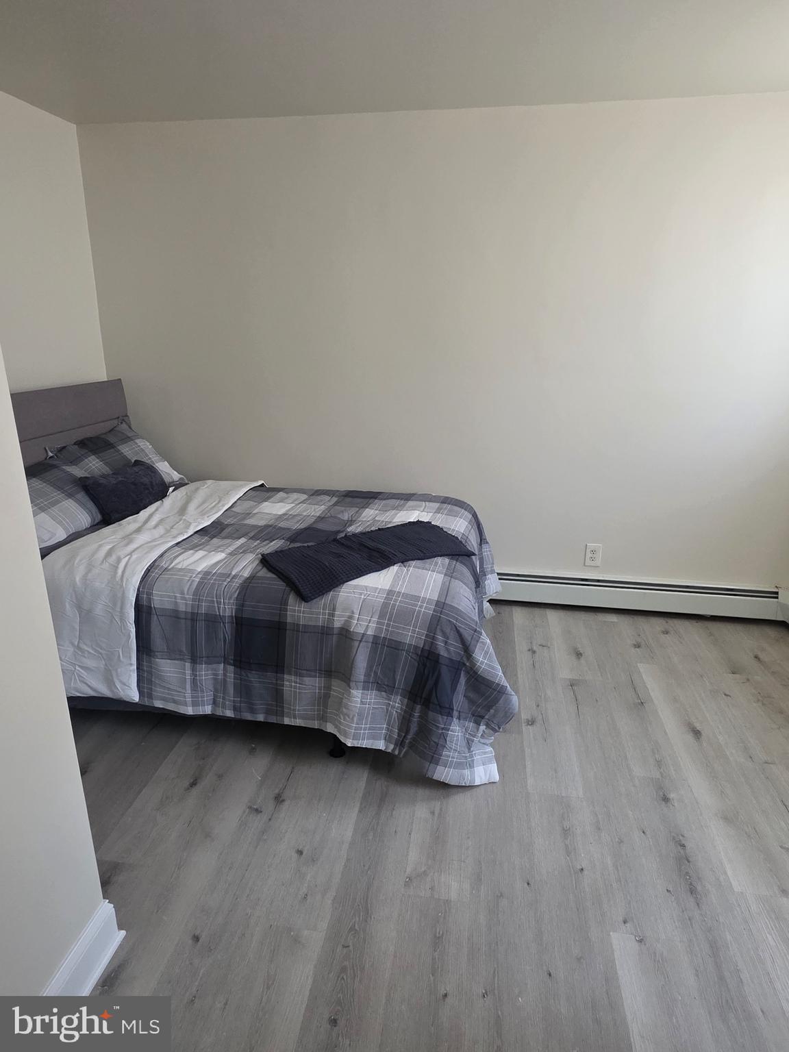 480 West South Street, Unit 1 Frederick, MD 21701 - Photo 15 of 17 a bedroom with a bed and wooden floor