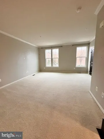 an empty room with a windows and a fireplace