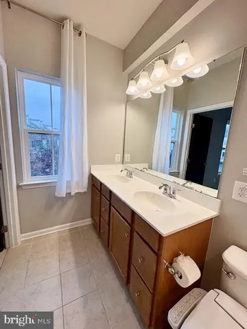 a bathroom with a sink a toilet a mirror and shower