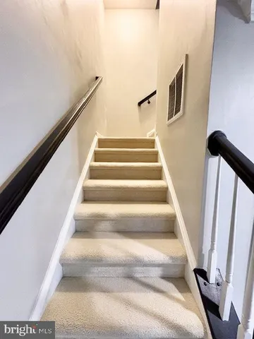 a view of staircase with white walls and a window