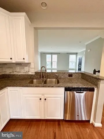 a kitchen with granite countertop a sink and cabinets