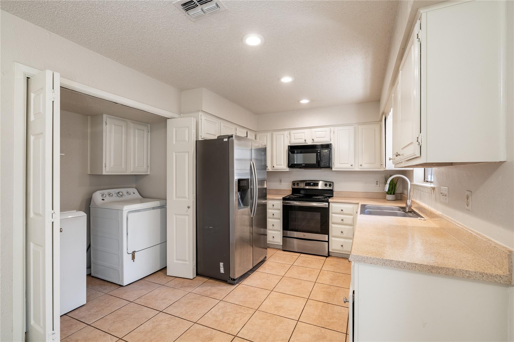 3800 Foust Trail, Unit B Georgetown, TX 78628 - Photo 7 of 16 A well-equipped culinary space featuring sleek stainless steel appliances and abundant white cabinetry.