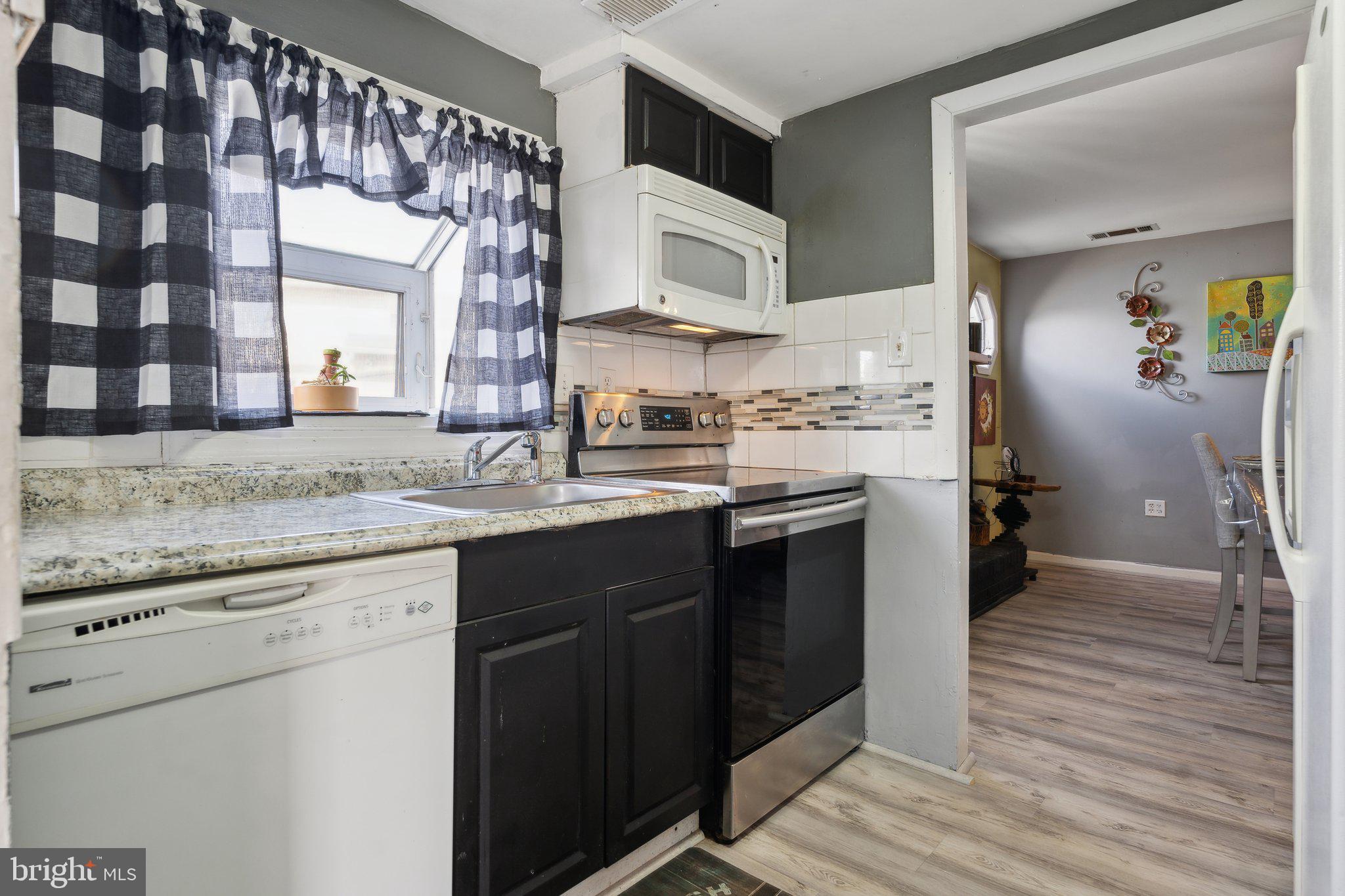 175 Seagull Drive Pasadena, MD 21122 - Photo 4 of 23 a kitchen with a sink cabinets and wooden floor