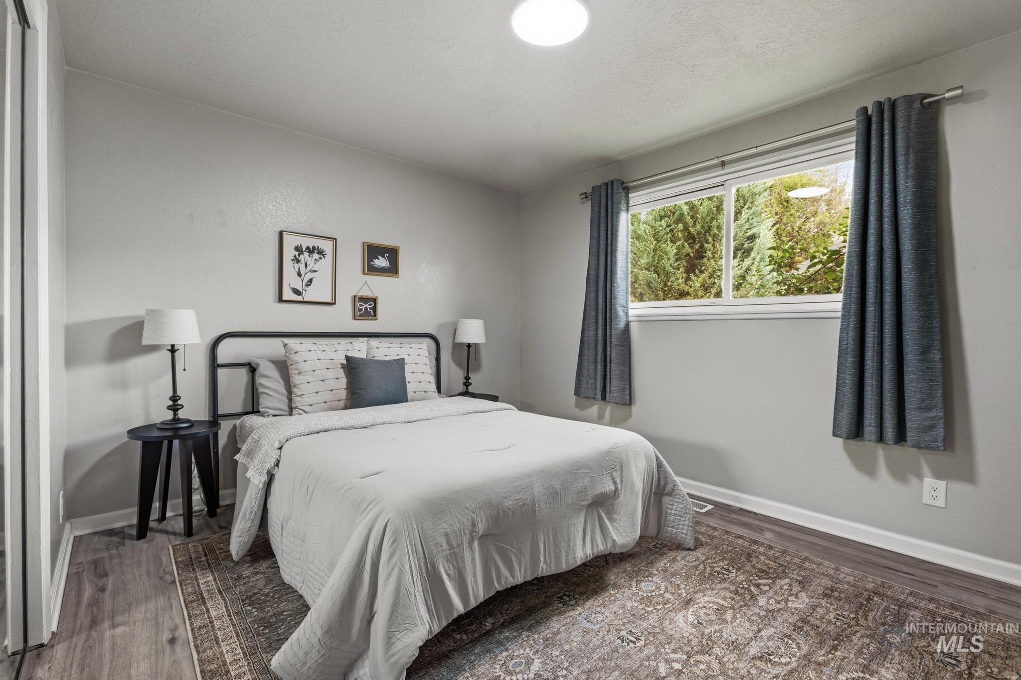 3040 West Hester Street Boise, ID 83702 - Photo 12 of 20 Bedroom featuring wood-finish flooring, a contemporary window, and soft gray wall tones