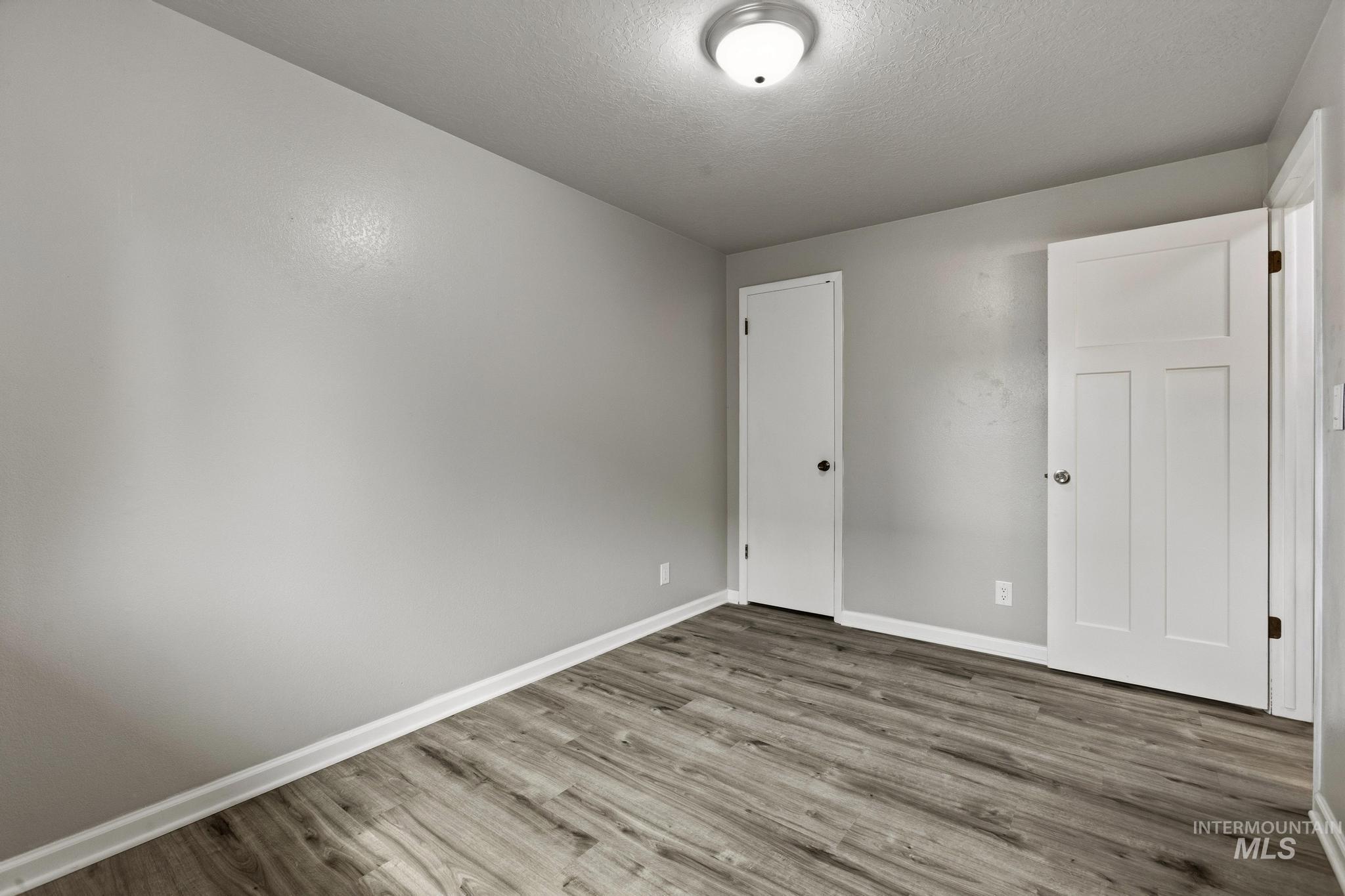 3040 West Hester Street Boise, ID 83702 - Photo 16 of 20 Room featuring wood-finish flooring, light grey walls, and white baseboards