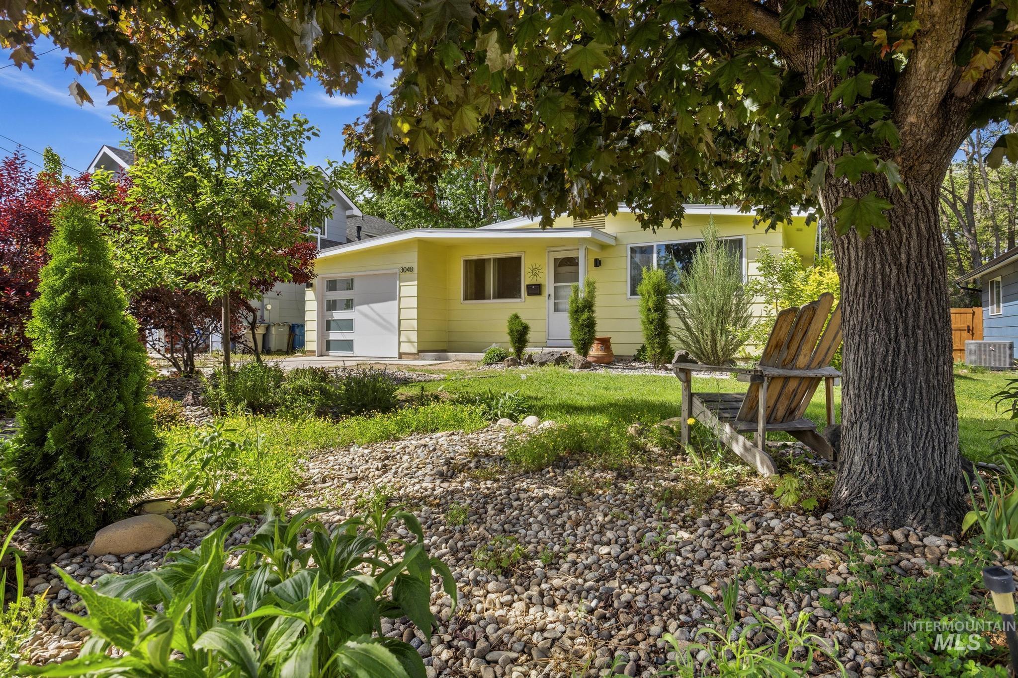 3040 West Hester Street Boise, ID 83702 - Photo 2 of 20 Front exterior featuring a light yellow facade with white trim, a modern garage door with frosted panels, and a white entry door