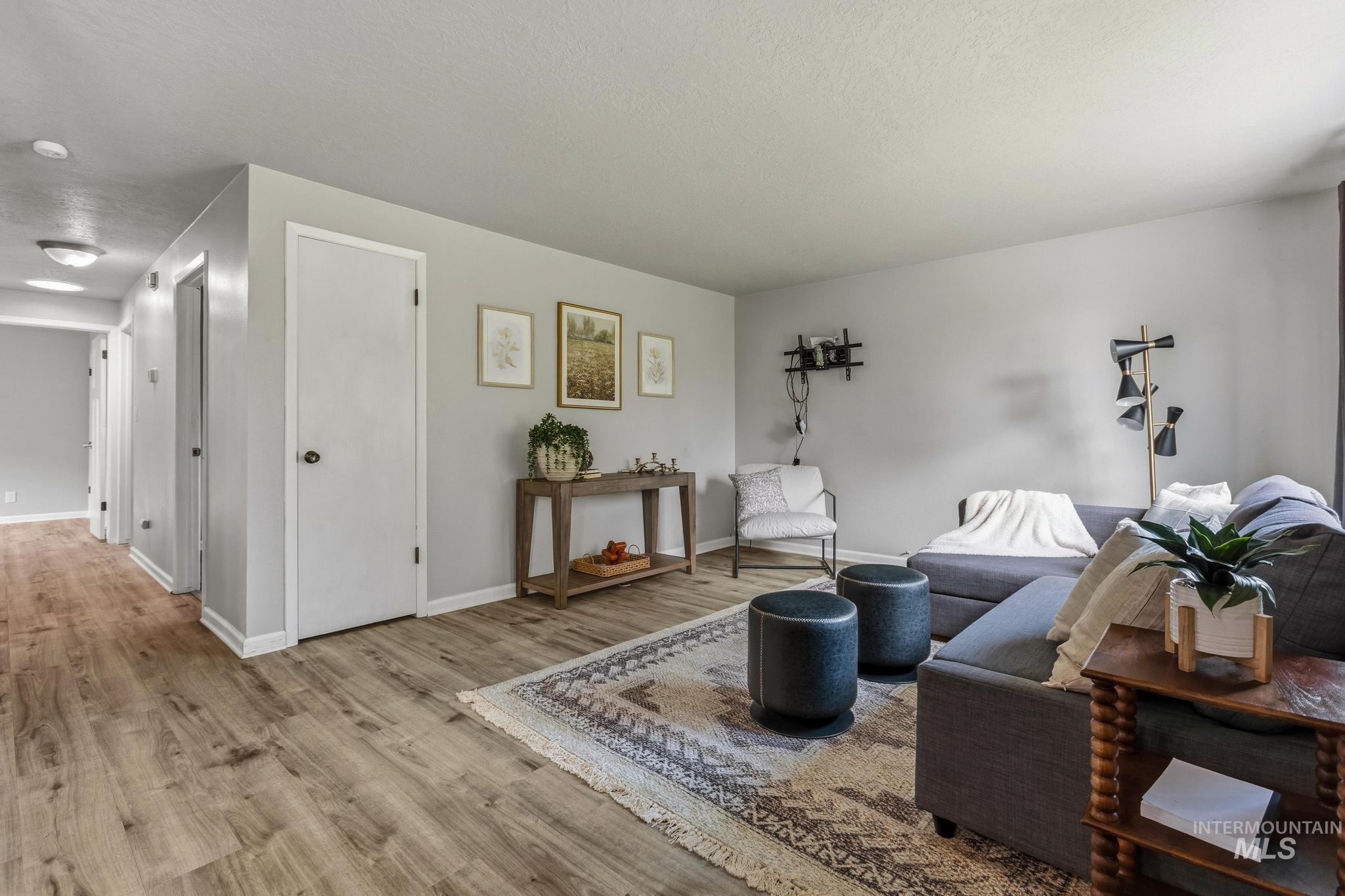 3040 West Hester Street Boise, ID 83702 - Photo 3 of 20 Spacious living area featuring wood-finish flooring, light gray wall paint, and white trim