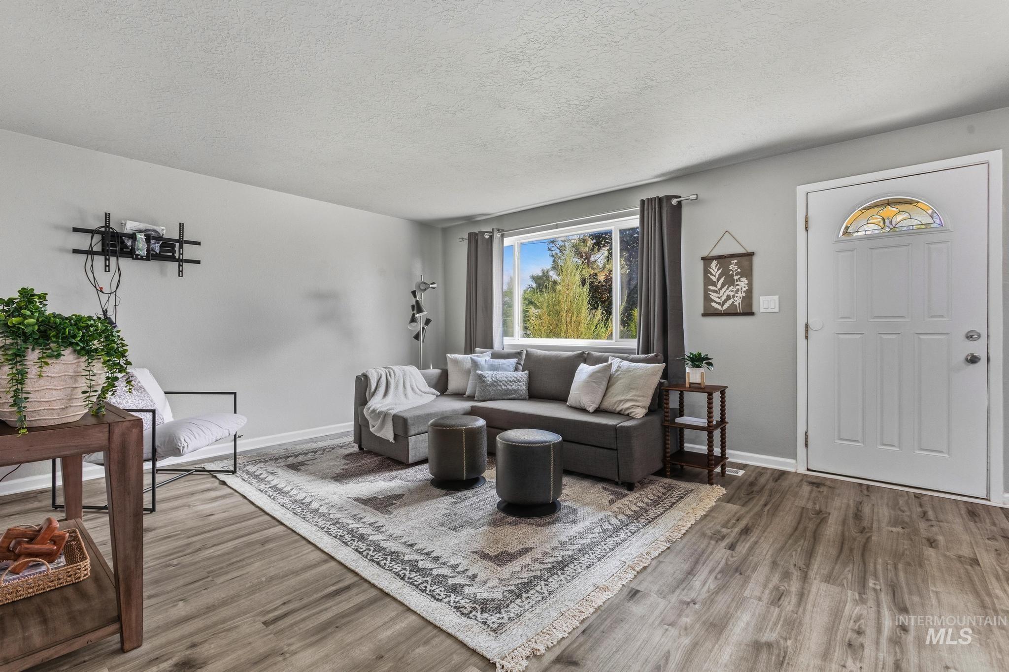 3040 West Hester Street Boise, ID 83702 - Photo 4 of 20 Spacious living area featuring wood-finish flooring, light gray wall paint, and a large window