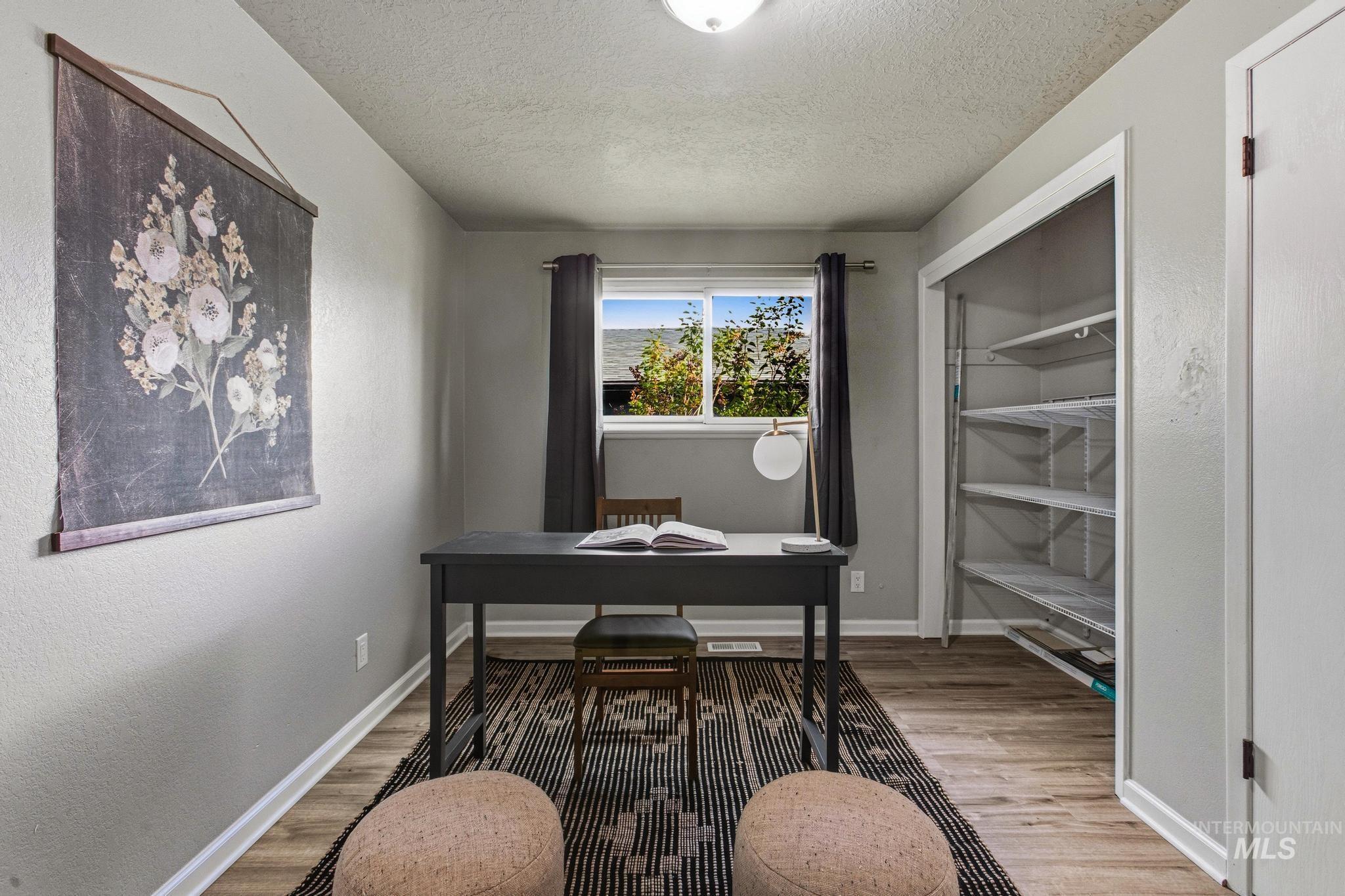 3040 West Hester Street Boise, ID 83702 - Photo 10 of 20 Room featuring a window, built-in closet shelving, wood-finish flooring, and light gray wall paint