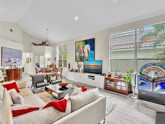 a living room with furniture a flat screen tv and a floor to ceiling window