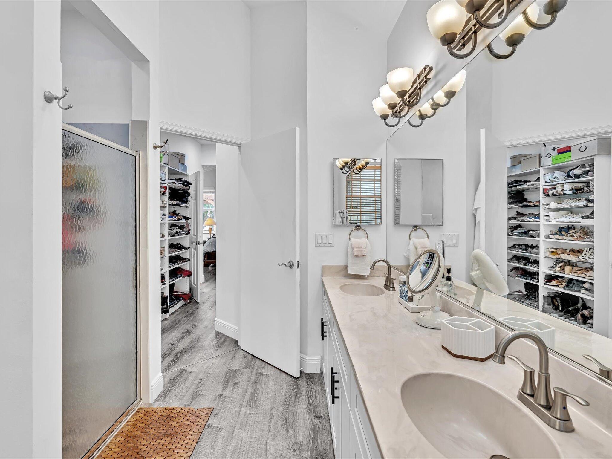 2486 Northwest 66th Drive Boca Raton, FL 33496 - Photo 19 of 80 a bathroom with a sink a chandelier and a mirror