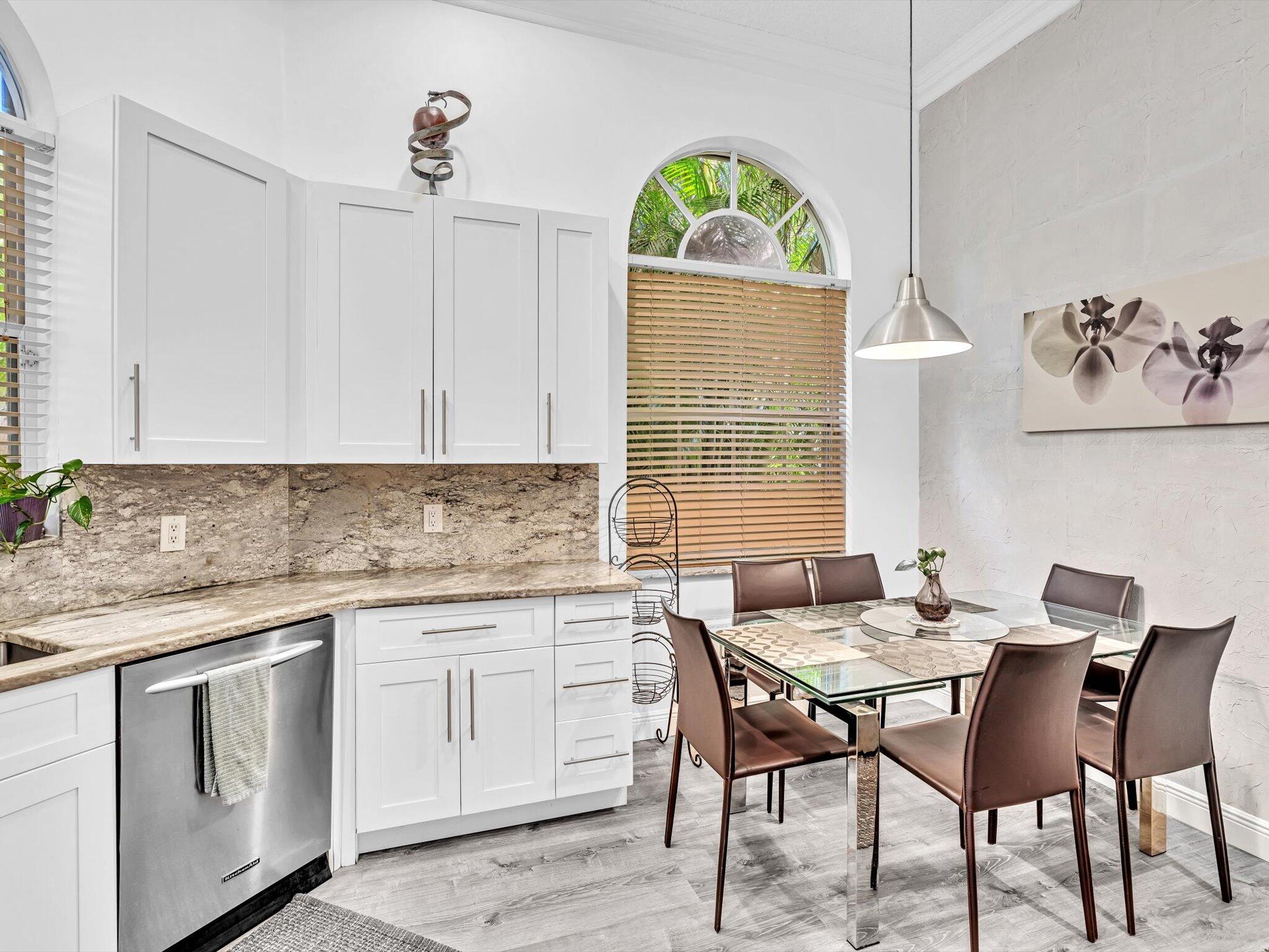 2486 Northwest 66th Drive Boca Raton, FL 33496 - Photo 30 of 80 a kitchen with a table chairs sink and cabinets