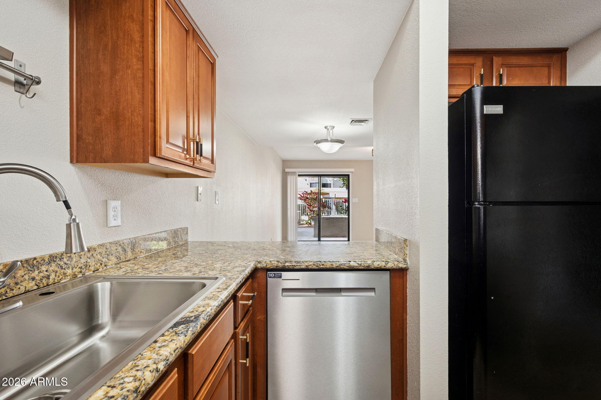 935 North Granite Reef Road, Unit 89 Scottsdale, AZ 85257 - Photo 7 of 32 a kitchen with granite countertop a refrigerator and a sink