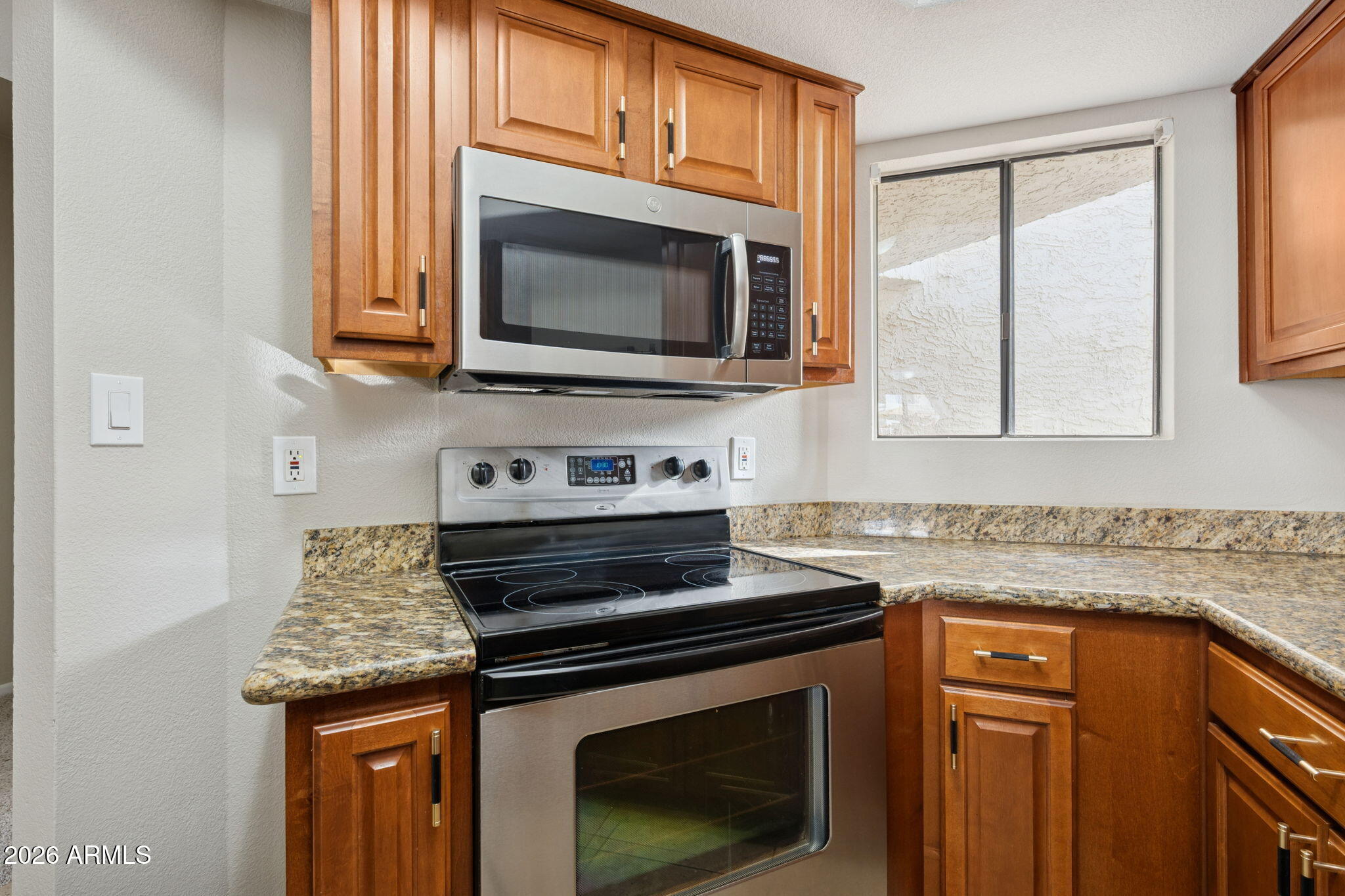 935 North Granite Reef Road, Unit 89 Scottsdale, AZ 85257 - Photo 8 of 32 a kitchen with granite countertop a stove microwave and sink