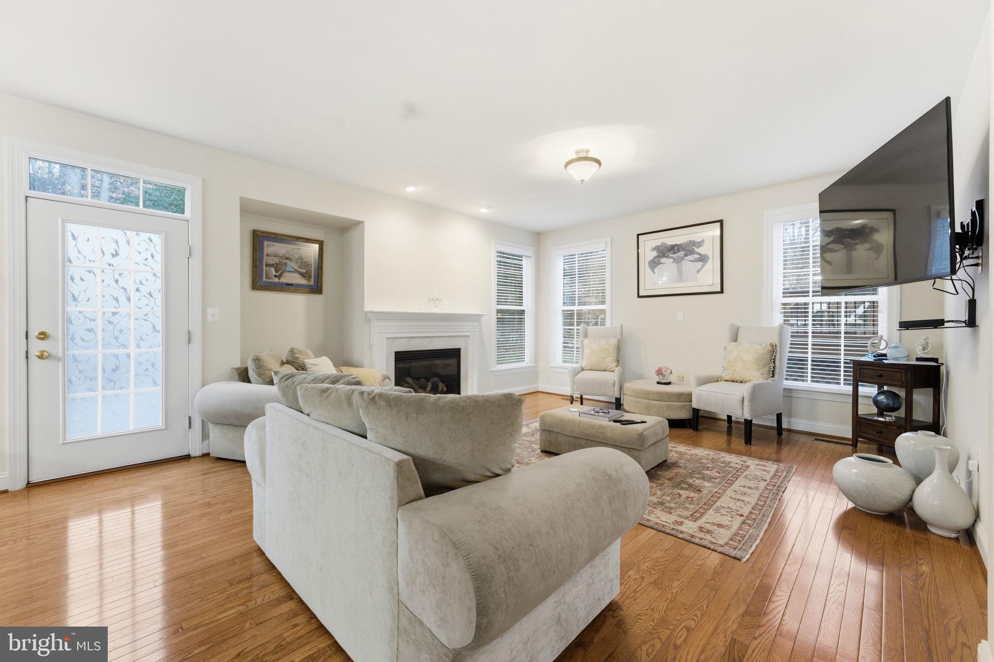 7669 Oak Field Court Springfield, VA 22153 - Photo 17 of 57 a living room with fireplace furniture and a wooden floor