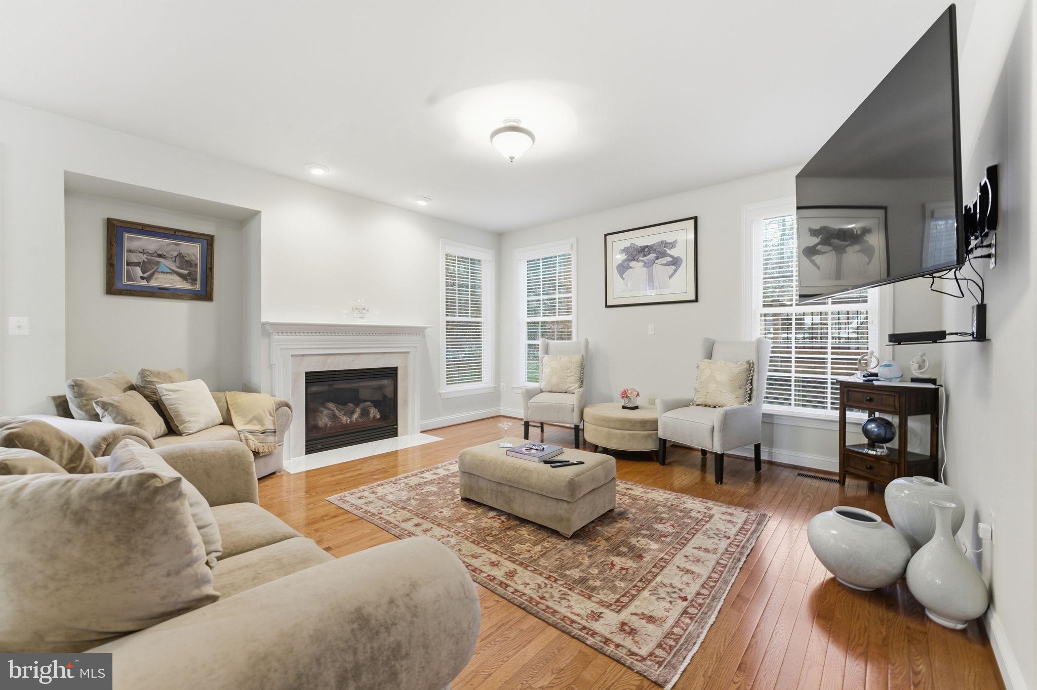 7669 Oak Field Court Springfield, VA 22153 - Photo 18 of 57 a living room with furniture couches and a fireplace