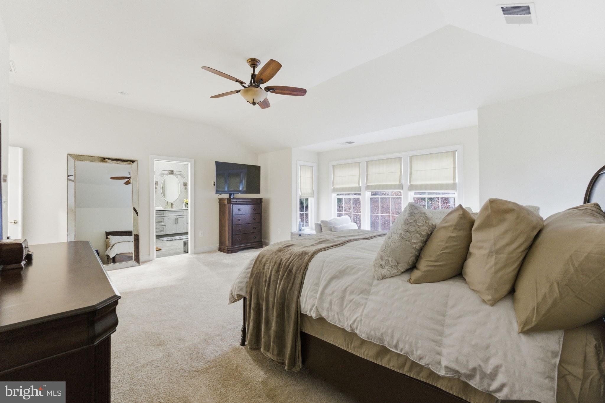 7669 Oak Field Court Springfield, VA 22153 - Photo 28 of 57 a bedroom with a large bed and a chandelier
