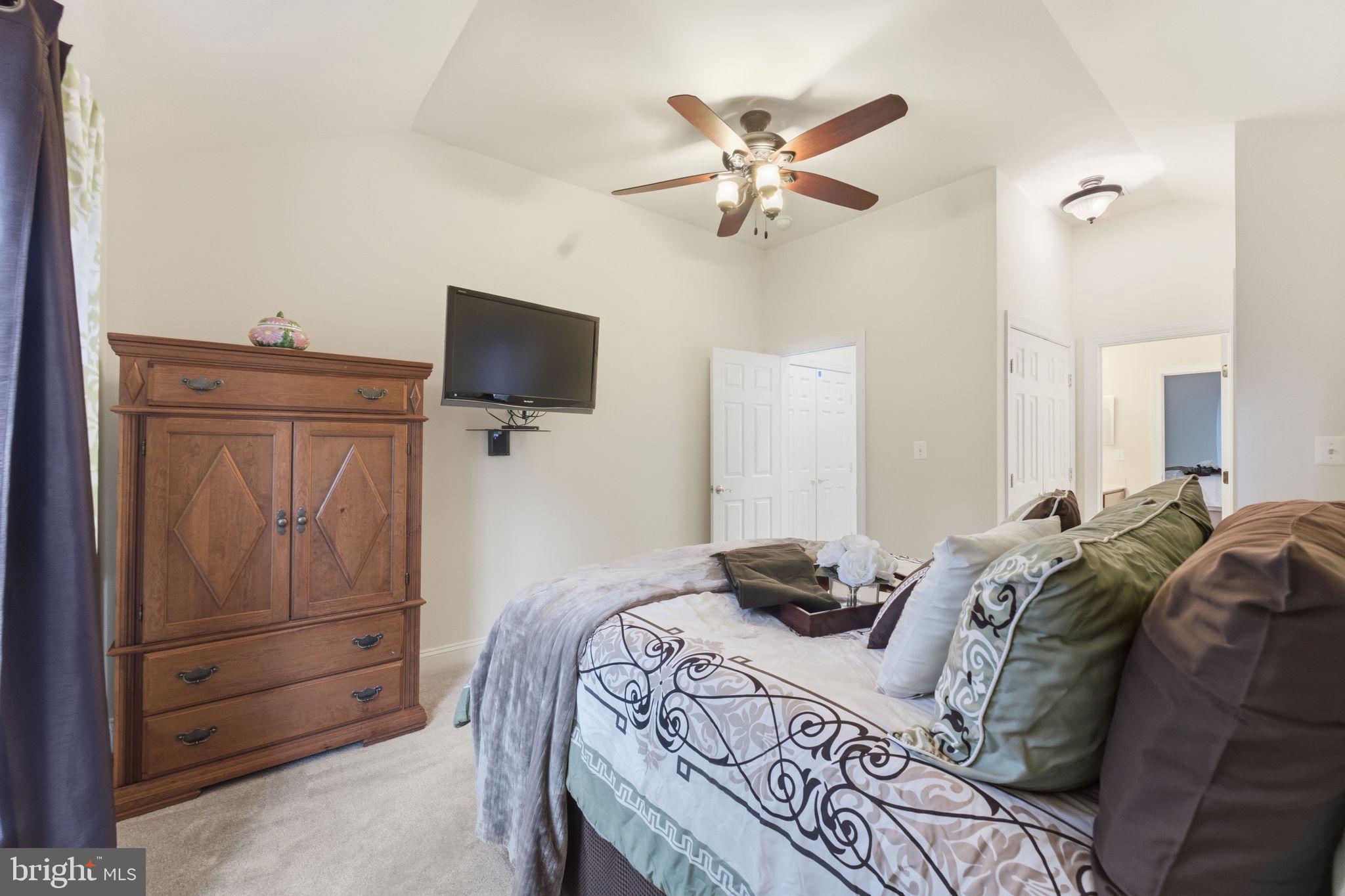 7669 Oak Field Court Springfield, VA 22153 - Photo 35 of 57 a bedroom with a bed and a flat tv screen
