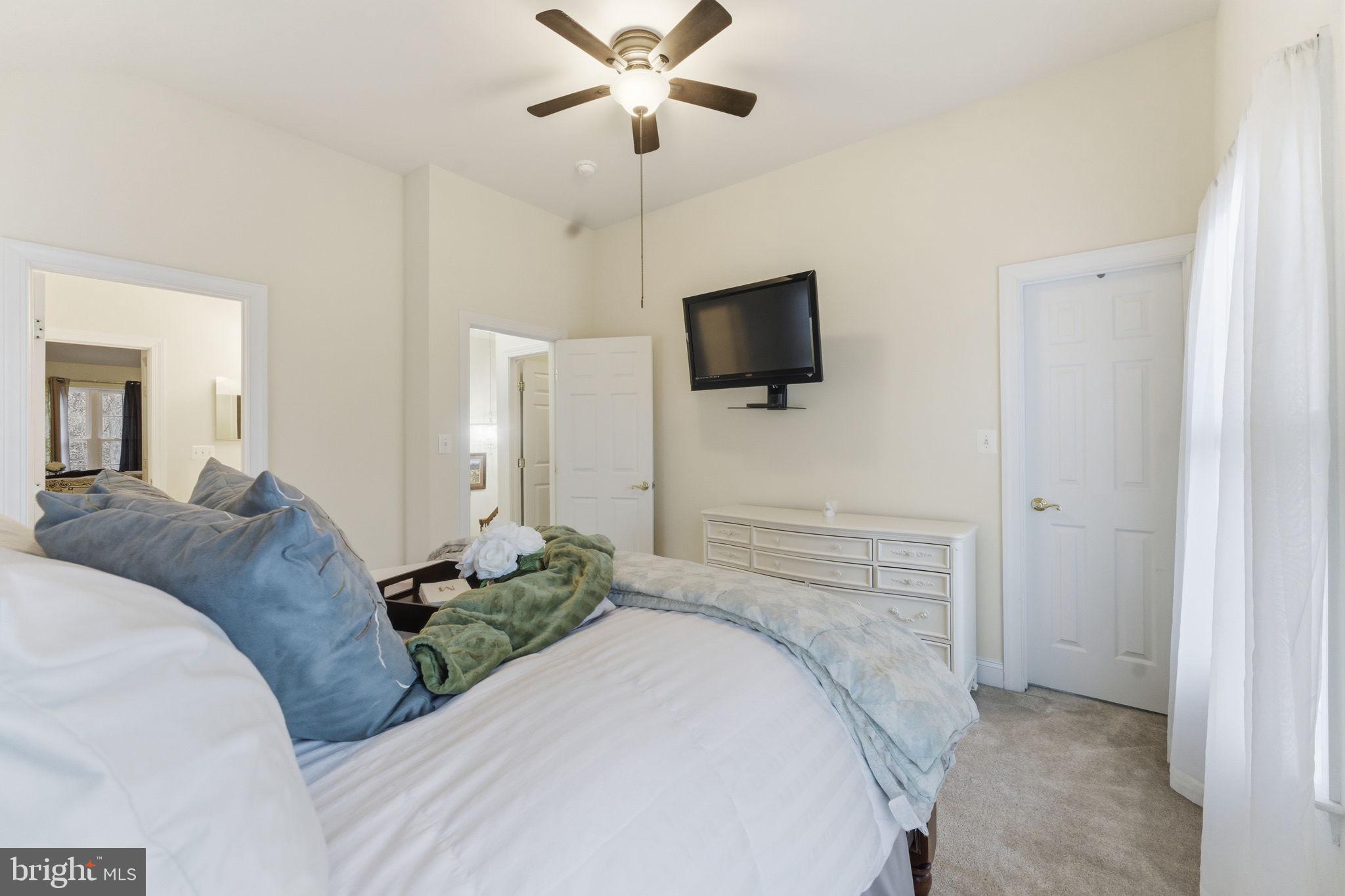 7669 Oak Field Court Springfield, VA 22153 - Photo 40 of 57 a bedroom with a bed and a flat screen tv