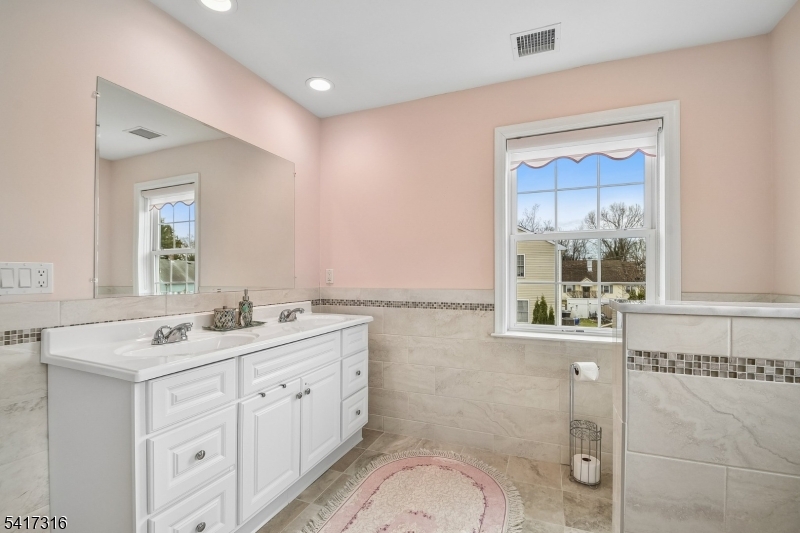 83 White Street Dover, NJ 07801 - Photo 14 of 26 a spacious bathroom with a double vanity sink a mirror and a shower