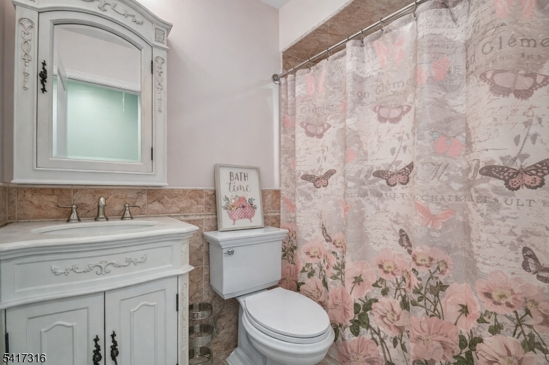 83 White Street Dover, NJ 07801 - Photo 21 of 26 a bathroom with a granite countertop sink mirror vanity and toilet