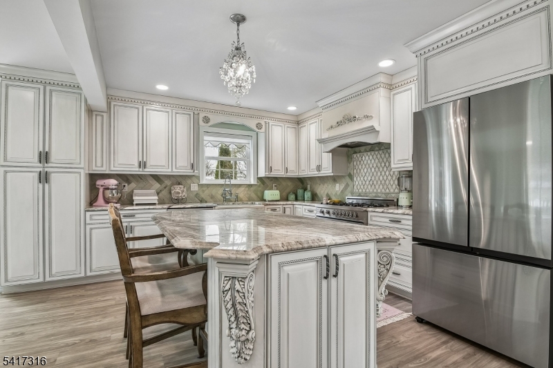 83 White Street Dover, NJ 07801 - Photo 5 of 26 a kitchen with kitchen island granite countertop a refrigerator a stove a sink and white cabinets with wooden floor
