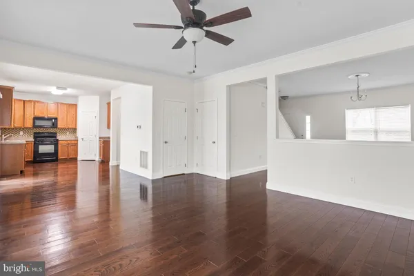 a view of a kitchen with wooden floor and a ceiling fan