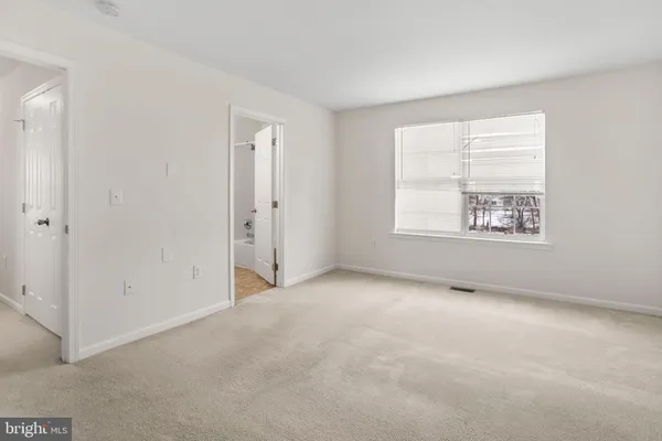 an empty room with windows and closet
