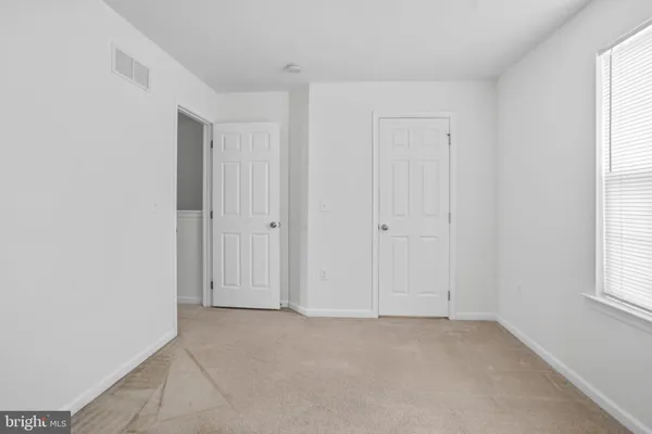 an empty room with windows and closet