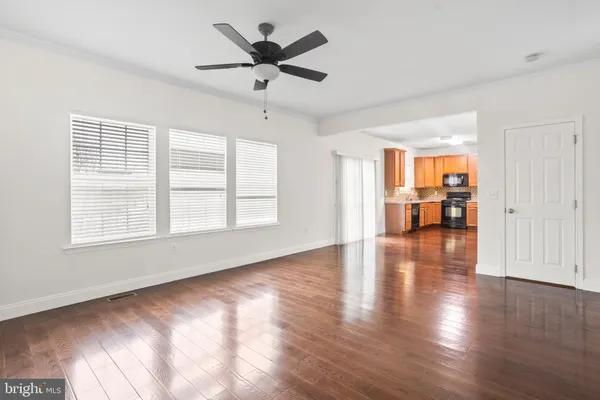 a view of an empty room with window and wooden floor