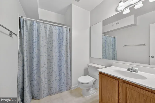 a bedroom with a bed and a dresser next to a window