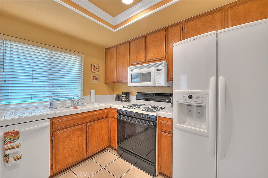 8576 Salina Street Rancho Cucamonga, CA 91730 - Photo 15 of 33 a kitchen with a sink cabinets stainless steel appliances and a window