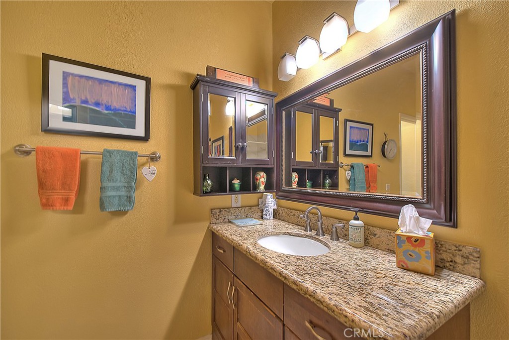 8576 Salina Street Rancho Cucamonga, CA 91730 - Photo 28 of 33 a bathroom with a granite countertop sink and a large mirror