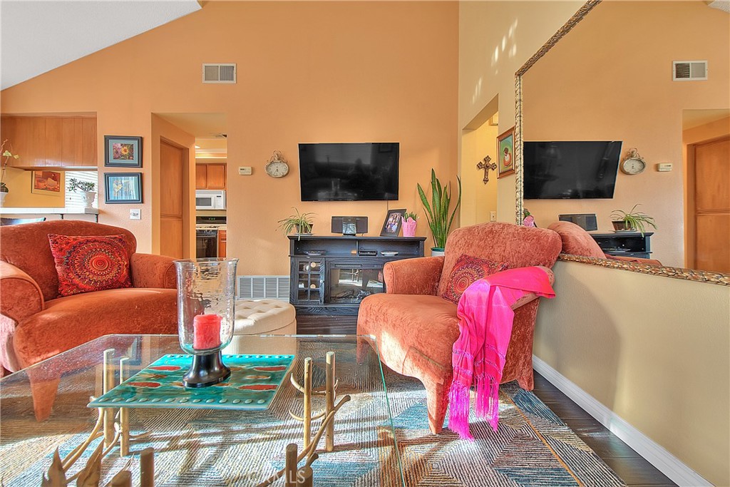 8576 Salina Street Rancho Cucamonga, CA 91730 - Photo 9 of 33 a living room with furniture a flat screen tv and a floor to ceiling window