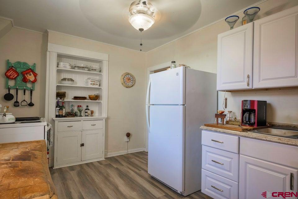 603 East First Street Trinidad, CO 81082 - Photo 24 of 37 a kitchen with granite countertop cabinets and refrigerator