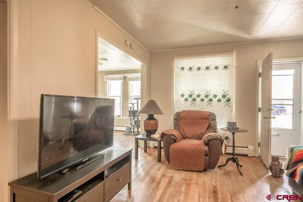 a view of a dining room with furniture a rug and wooden floor