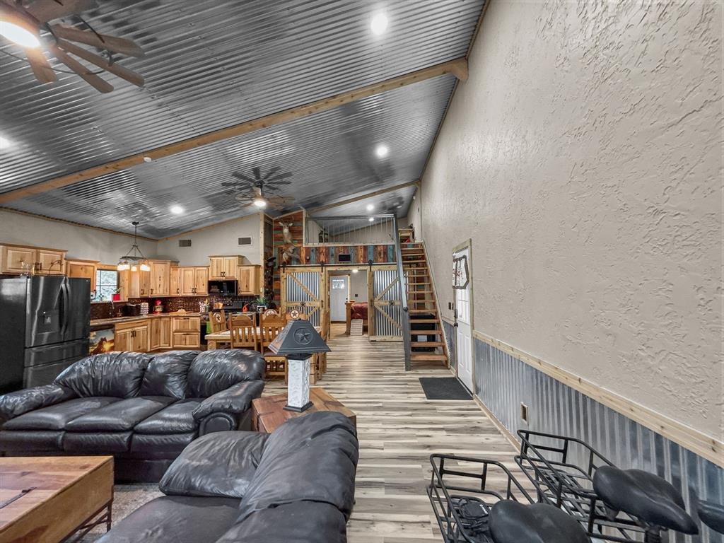 1477 Cedar Mills Road Gordonville, TX 76245 - Photo 4 of 21 Living area featuring wainscoting, light wood-style flooring, stairway, and ceiling fan