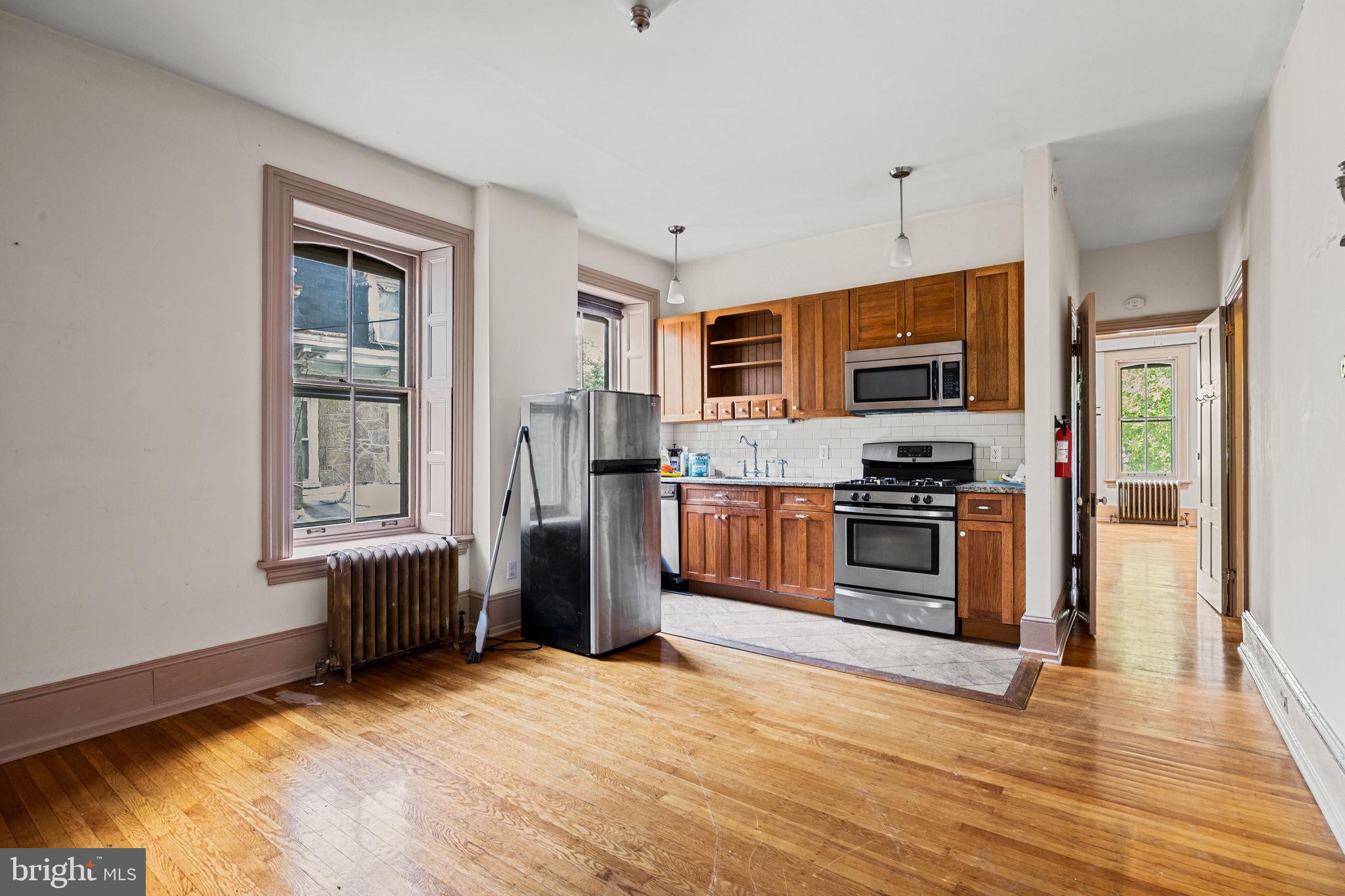 5911 Greene Street Philadelphia, PA 19144 - Photo 27 of 52 a kitchen with stainless steel appliances kitchen island granite countertop a stove a sink and a refrigerator
