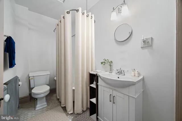 a bathroom with a sink a toilet and a mirror