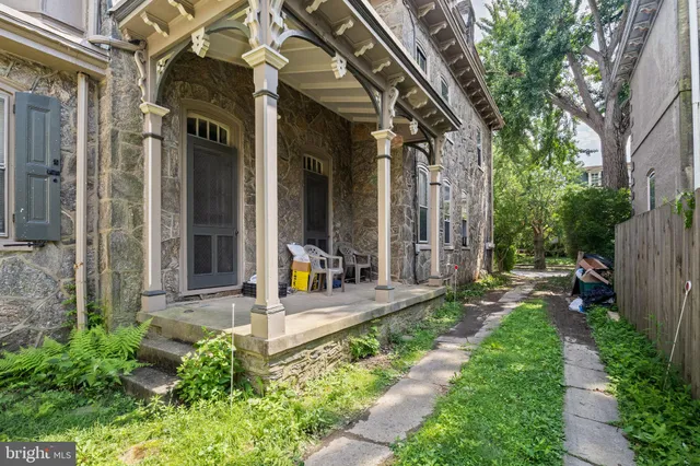a view of a house with brick walls and a yard with plants