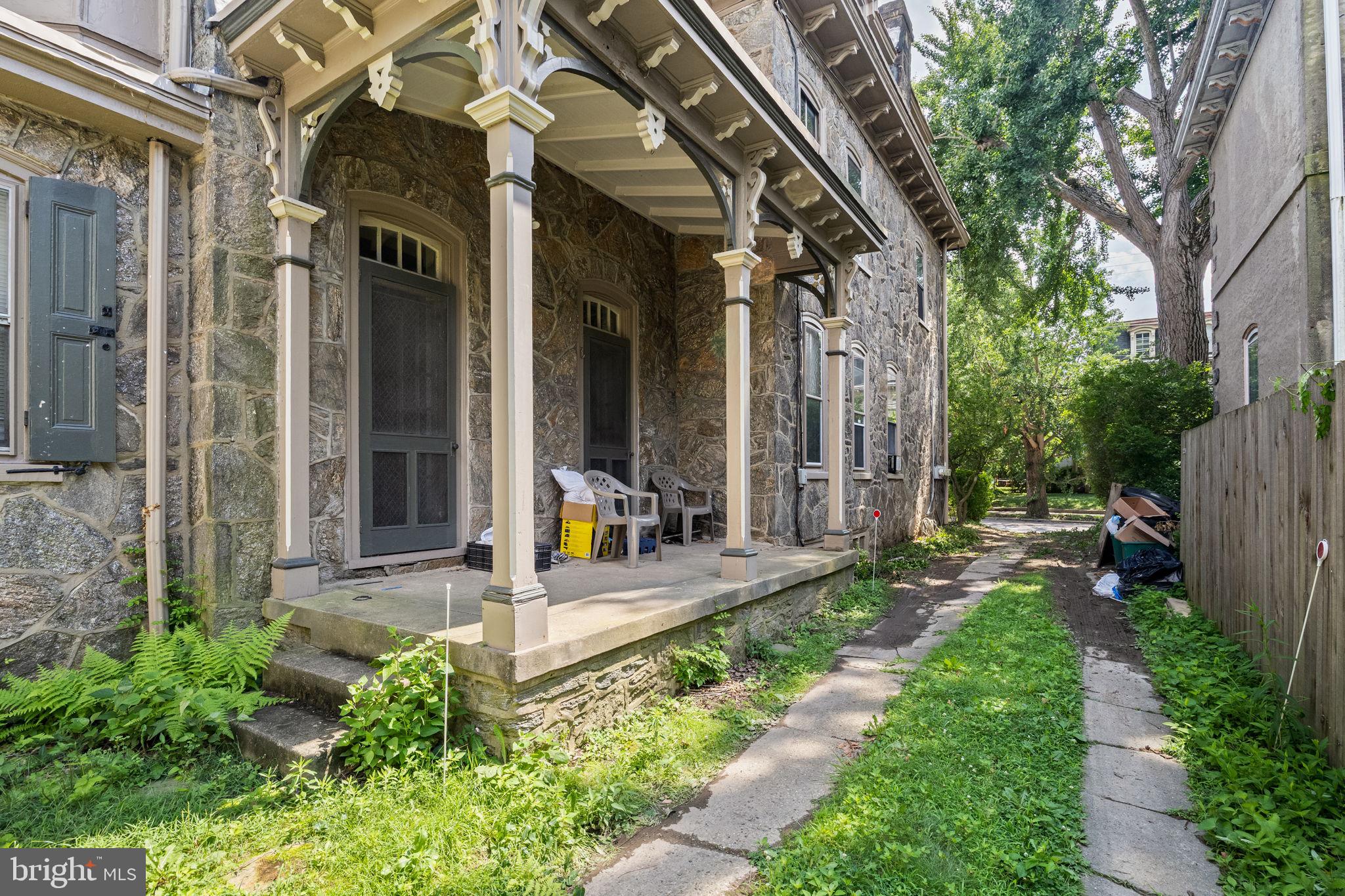 5911 Greene Street Philadelphia, PA 19144 - Photo 44 of 52 a view of a house with brick walls and a yard with plants