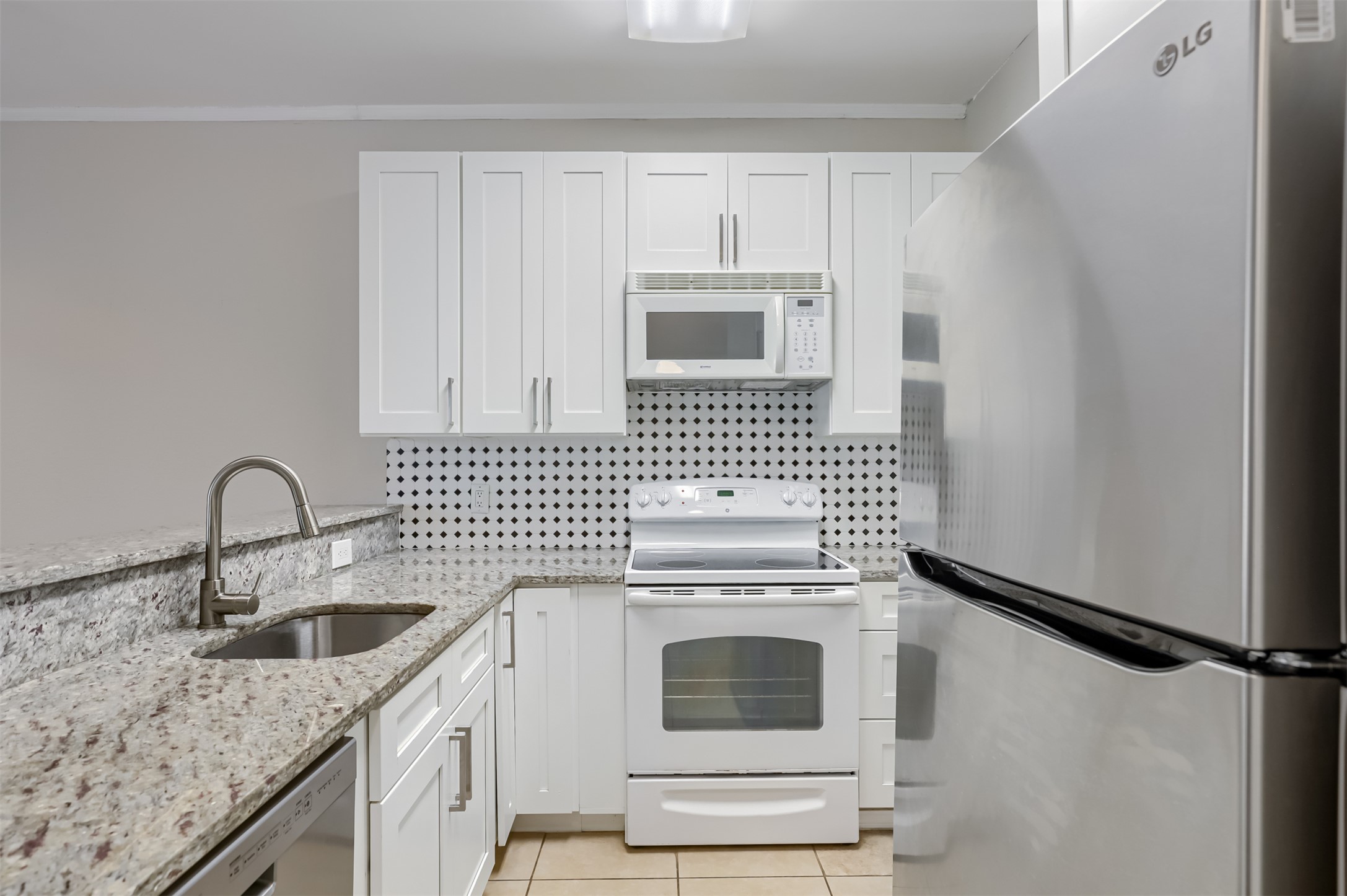 802 South 1st Street, Unit 206 Austin, TX 78704 - Photo 5 of 18 a kitchen with white cabinets a sink and a stove with wooden floor
