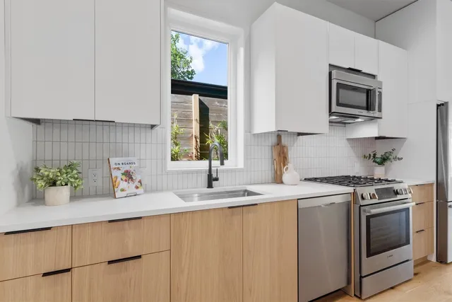 a kitchen with stainless steel appliances white cabinets and a sink