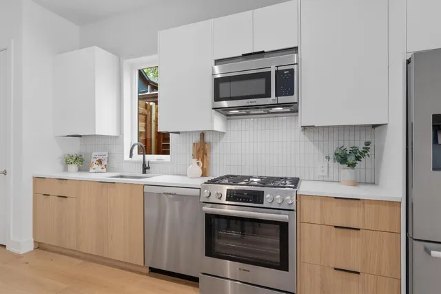 a kitchen with cabinets stainless steel appliances and wooden floor