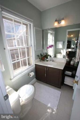 1123 Portner Road Alexandria, VA 22314 - Photo 6 of 10 a bathroom with a double vanity sink a toilet and a mirror